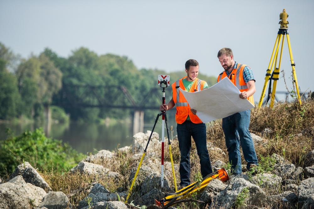 Two surveying professionals looking at blueprints